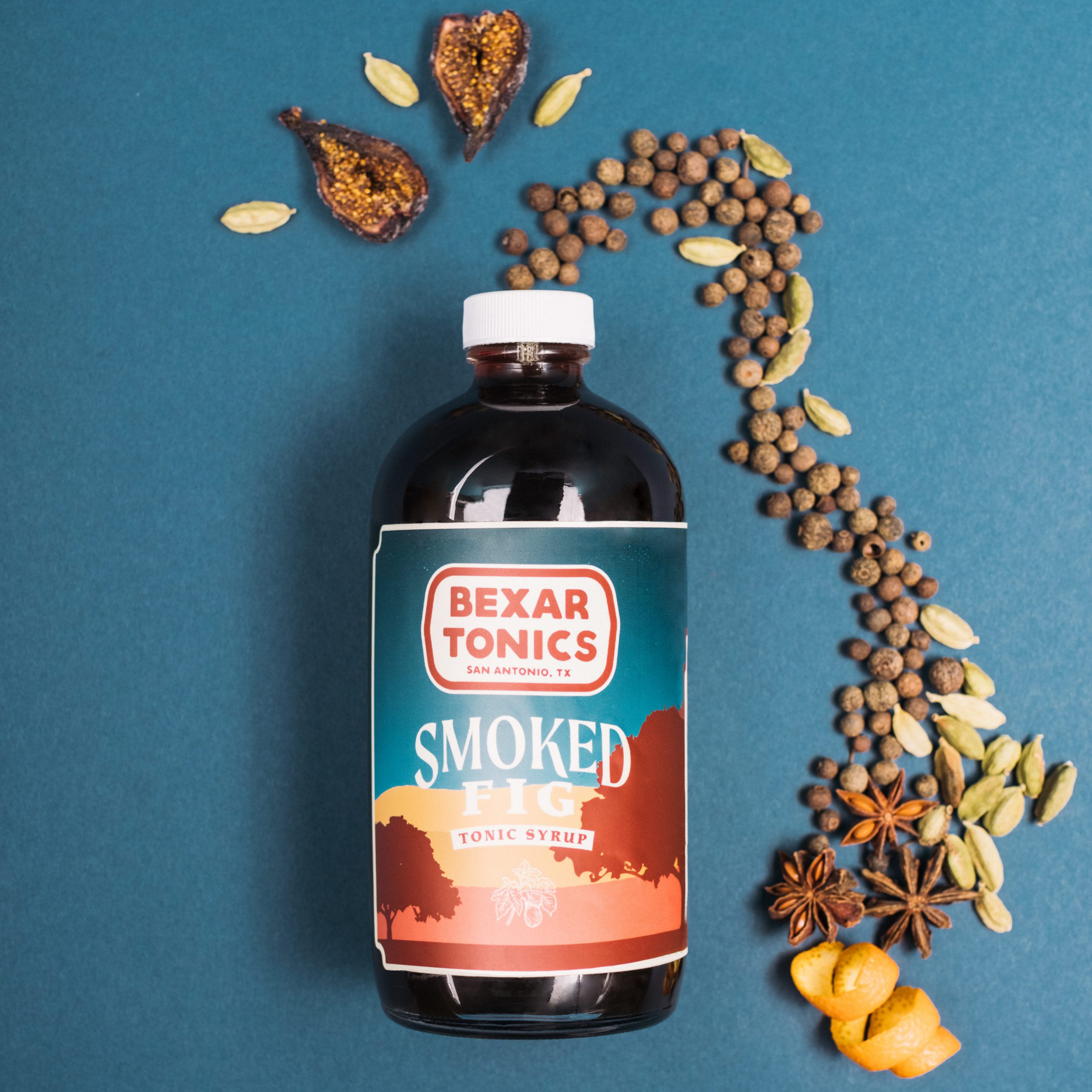 bottle smoked fig tonic syrup surrounded by ingredients