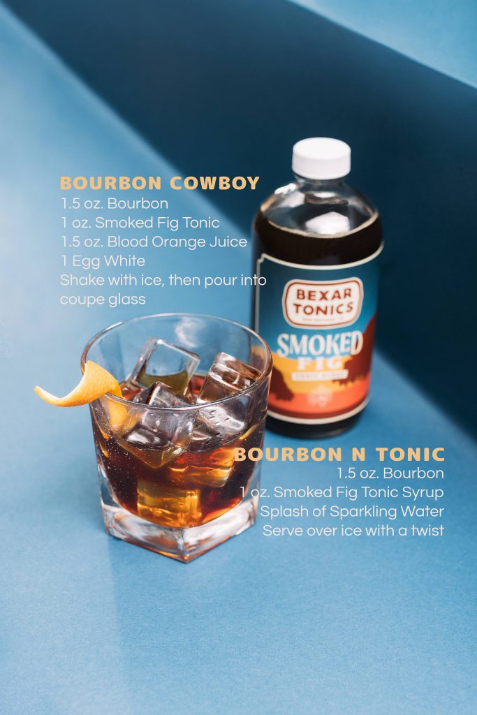 bottle of smoked fig tonic syrup with bourbon cocktail