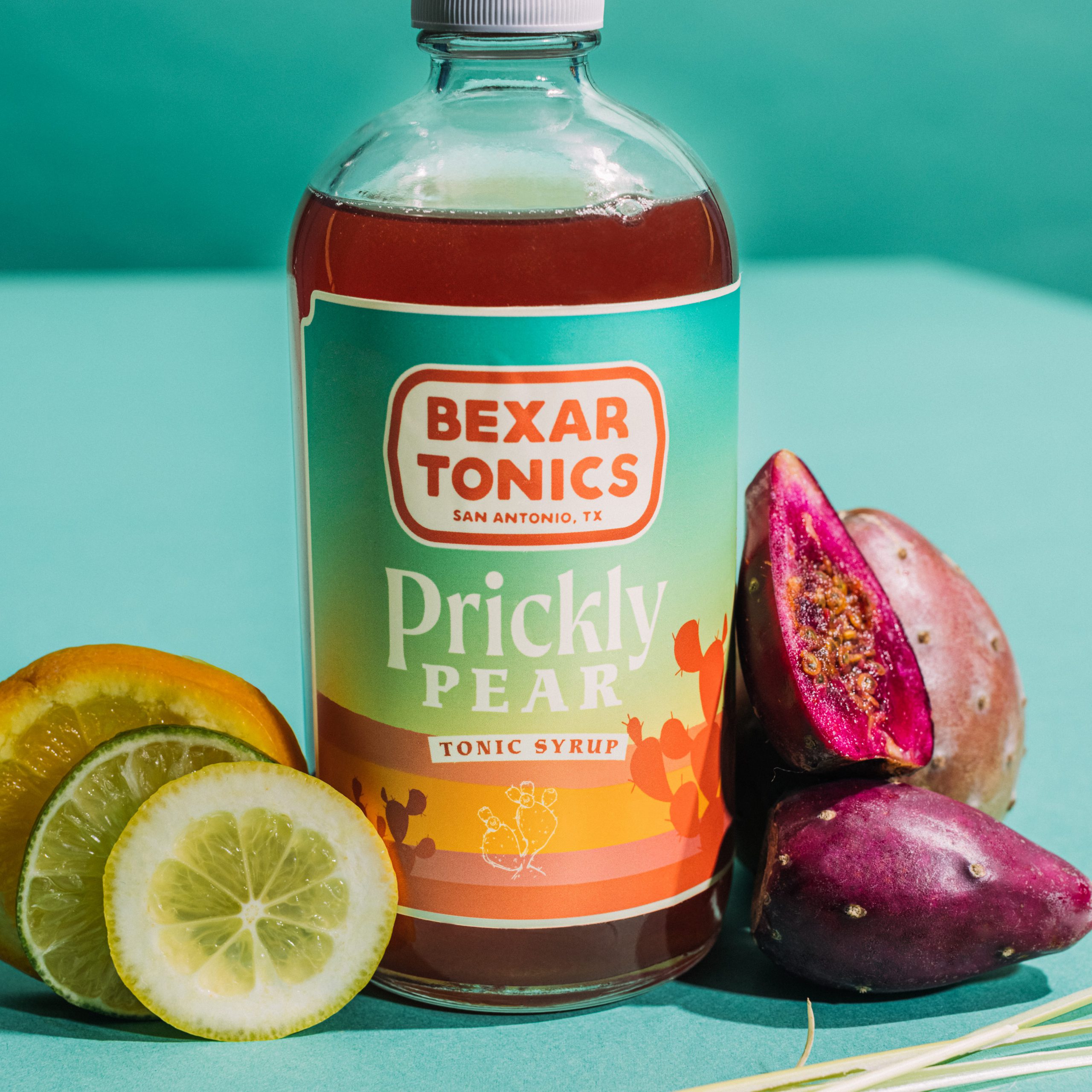 bottle of prickly pear tonic with prickly pears and citrus